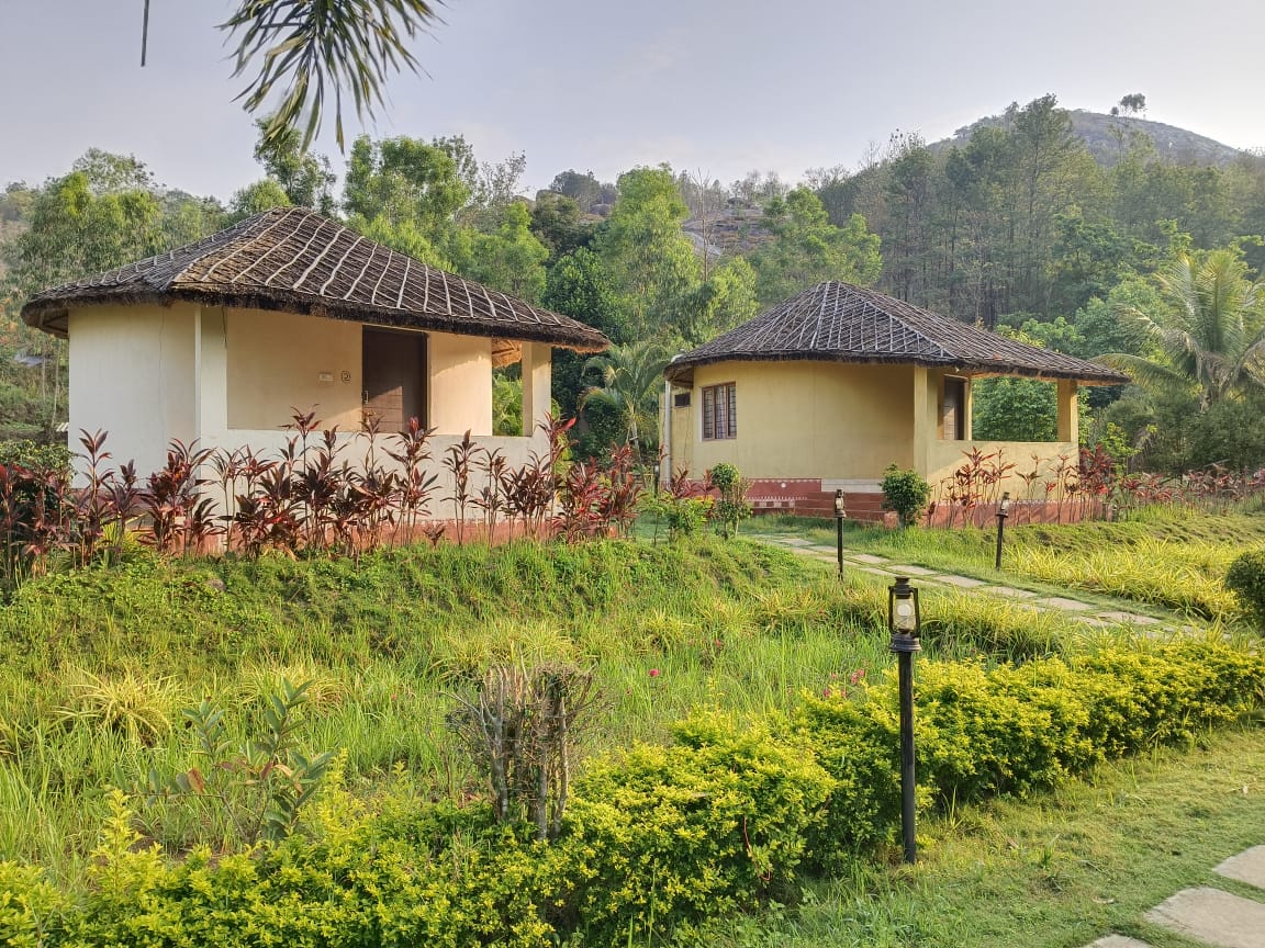 Thatched cottages with mountain hills backdrop